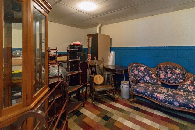 sitting room with wainscoting and a drop ceiling