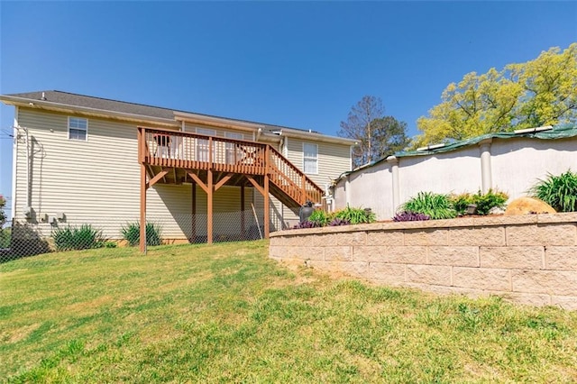 deck with stairs, fence, and a yard