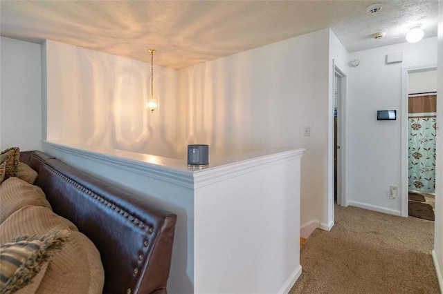hall with baseboards and carpet flooring