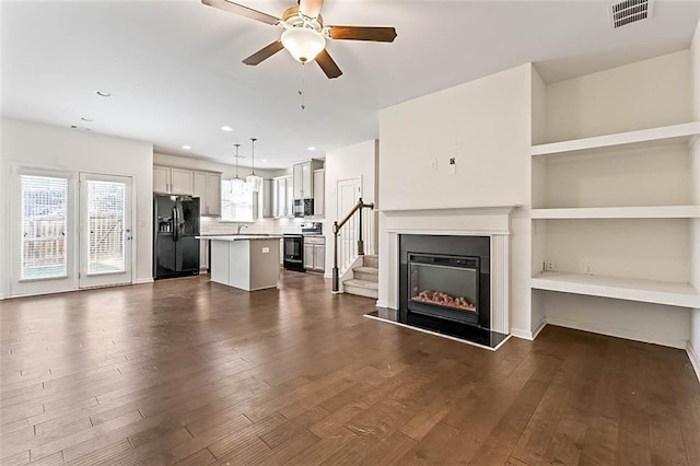 unfurnished living room with dark hardwood / wood-style flooring, ceiling fan, built in features, and sink