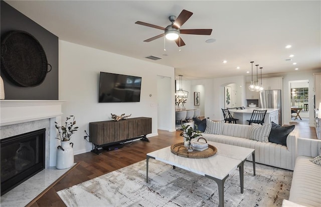 living room featuring ceiling fan, wood-type flooring, and a premium fireplace