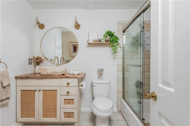 full bath featuring tile patterned floors, vanity, toilet, and bath / shower combo with glass door