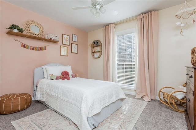 bedroom featuring a ceiling fan, baseboards, multiple windows, and carpet flooring