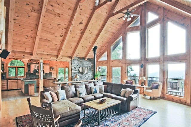 living room with beam ceiling, wooden walls, wood ceiling, and light wood-type flooring