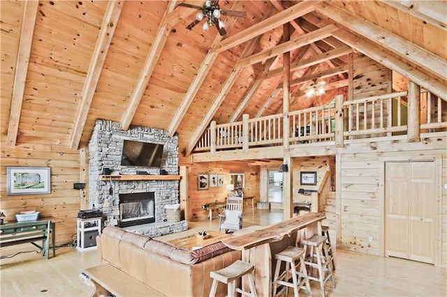 living room featuring beam ceiling, light wood-type flooring, wood ceiling, and wood walls