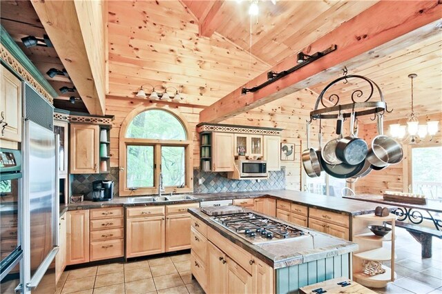 kitchen with stainless steel appliances, wood walls, a center island, and light tile patterned flooring