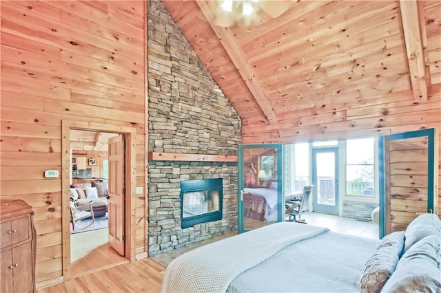 bedroom with wood walls, light hardwood / wood-style flooring, beamed ceiling, and wood ceiling