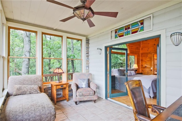 sunroom featuring ceiling fan, plenty of natural light, and wooden ceiling