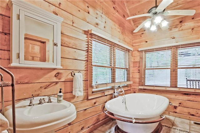 bathroom with wooden walls, sink, ceiling fan, and a bath