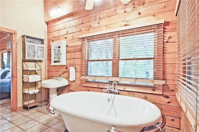 bathroom featuring wood walls, tile patterned flooring, and a washtub