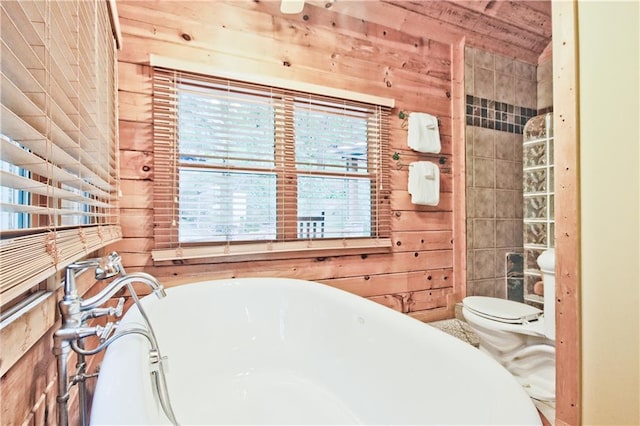 bathroom featuring wooden walls, toilet, and a tub to relax in