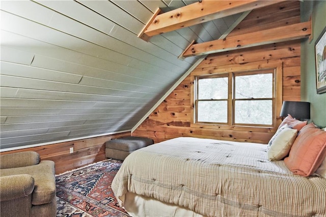 bedroom with wood walls, lofted ceiling with beams, and wooden ceiling