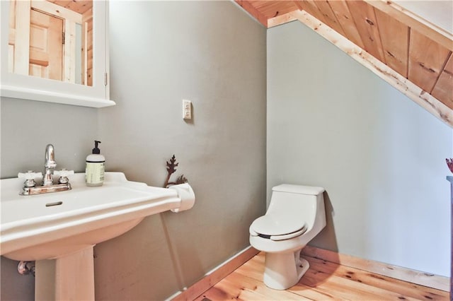 bathroom featuring toilet, sink, and wood-type flooring