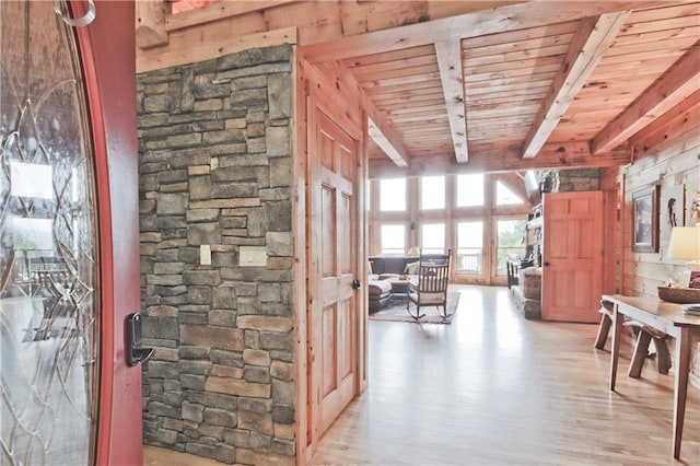 corridor featuring wooden walls, wooden ceiling, and light wood-type flooring