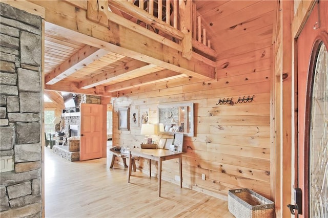 hallway with light hardwood / wood-style flooring, wooden walls, and wood ceiling