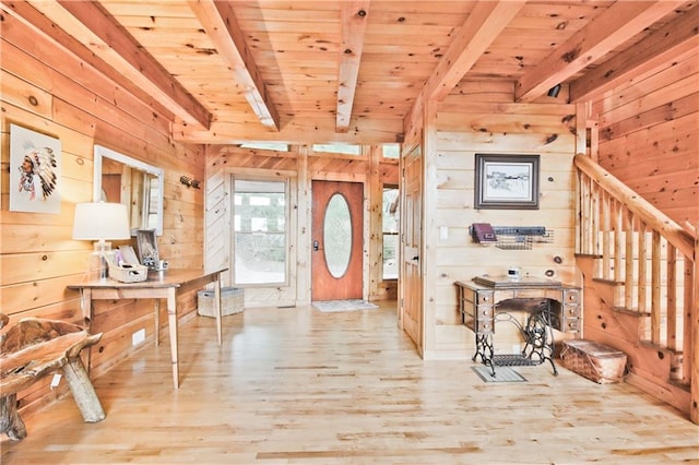 foyer entrance featuring wood walls, light hardwood / wood-style flooring, beamed ceiling, and wooden ceiling