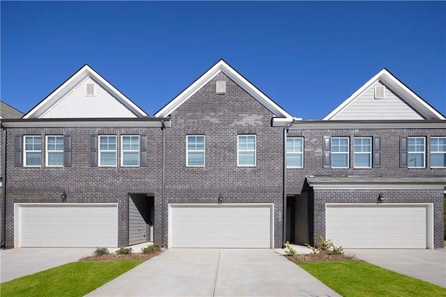 townhome / multi-family property featuring board and batten siding, brick siding, driveway, and a garage