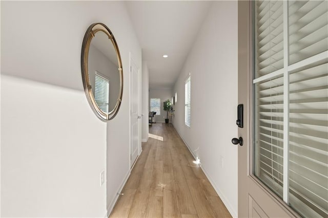 hall with light wood-type flooring, baseboards, and recessed lighting