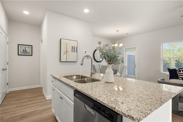 kitchen featuring dishwasher, light wood-style floors, a sink, and a chandelier