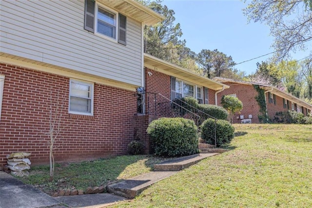 view of property exterior with a lawn and brick siding