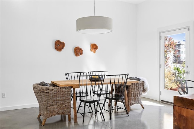 dining room featuring baseboards and concrete floors