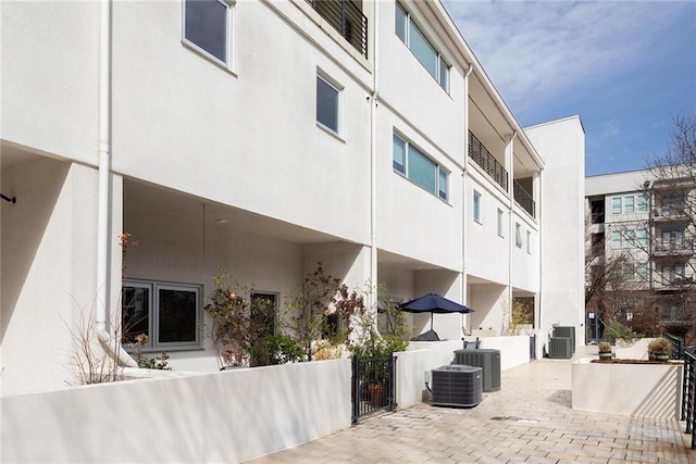 view of property with central AC and fence