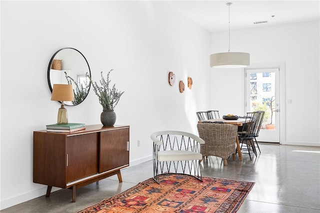 dining space with baseboards and concrete floors