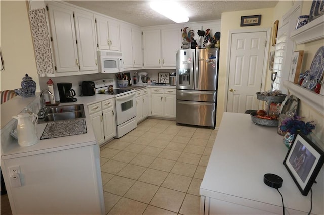 kitchen with light tile patterned floors, light countertops, white cabinets, a sink, and white appliances