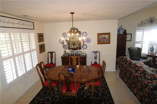 dining space featuring light tile patterned floors, a notable chandelier, visible vents, and a healthy amount of sunlight