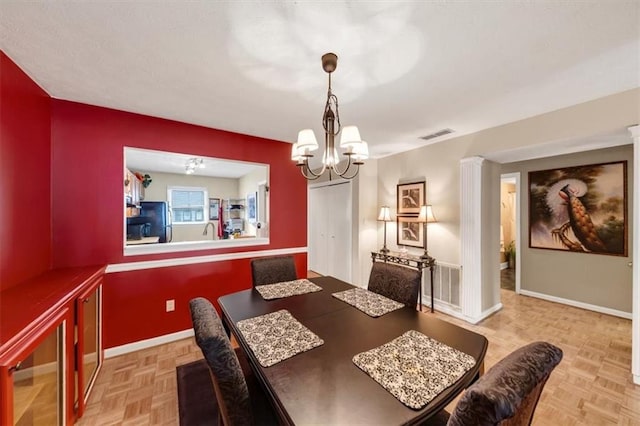 dining area with a chandelier and baseboards