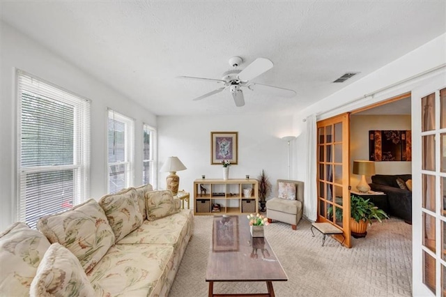 carpeted living room with ceiling fan