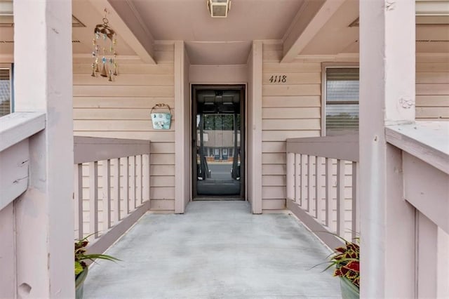 view of exterior entry featuring covered porch