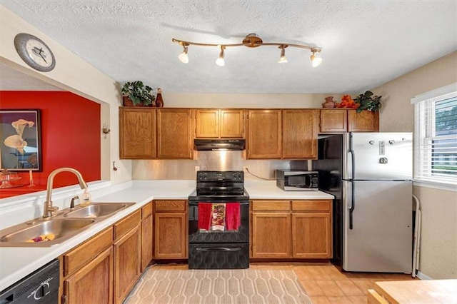 kitchen with black appliances, a sink, brown cabinets, light countertops, and a textured ceiling