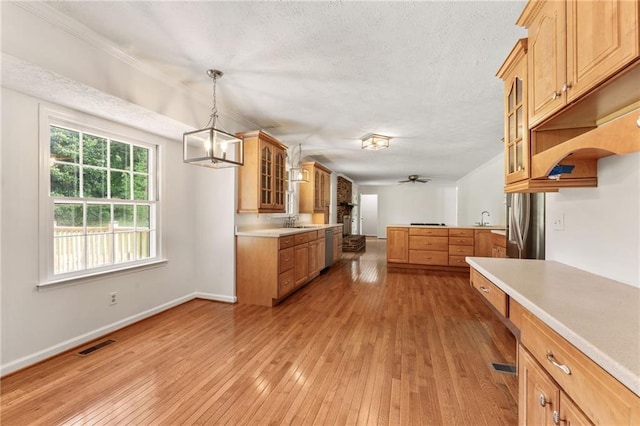 4135 Shoshone Valley Rd, Marietta, GA 30068 - kitchen featuring glass insert cabinets, light wood-style floors, light countertops, ceiling fan, and hanging light fixtures