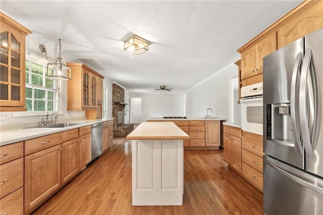 4135 Shoshone Valley Rd, Marietta, GA 30068 - kitchen with appliances with stainless steel finishes, light wood finished floors, a ceiling fan, glass insert cabinets, and crown molding