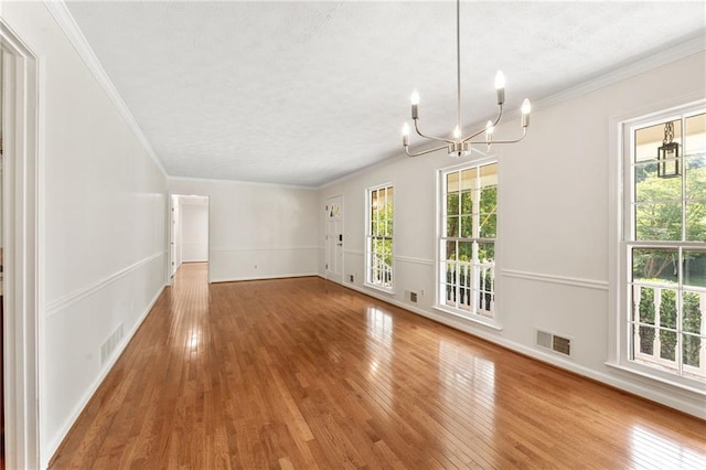 4135 Shoshone Valley Rd, Marietta, GA 30068 - unfurnished living room with a textured ceiling, a chandelier, healthy amount of natural light, wood finished floors, and crown molding