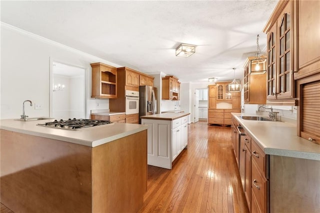 4135 Shoshone Valley Rd, Marietta, GA 30068 - kitchen featuring stainless steel appliances, a center island, open shelves, light wood-style floors, and ornamental molding