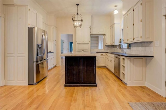 kitchen with white cabinets, decorative backsplash, hanging light fixtures, a center island, and stainless steel appliances