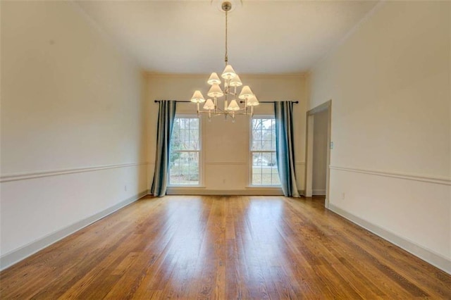 spare room with hardwood / wood-style floors and a chandelier