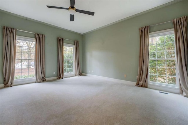 unfurnished room featuring ceiling fan, light colored carpet, and ornamental molding