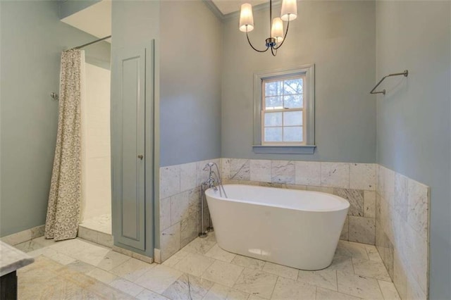 bathroom with an inviting chandelier and shower with separate bathtub