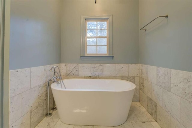 bathroom featuring tile walls, a bathtub, and tile patterned floors