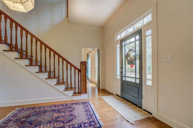 entrance foyer featuring ornamental molding and light hardwood / wood-style floors