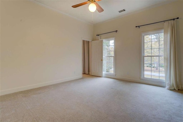 empty room with light carpet, ceiling fan, ornamental molding, and a healthy amount of sunlight