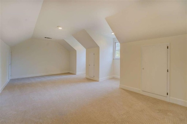 bonus room featuring lofted ceiling and light carpet