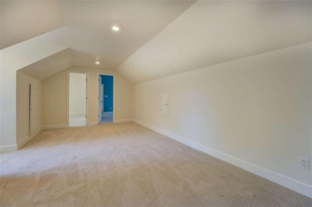 bonus room with light colored carpet and vaulted ceiling