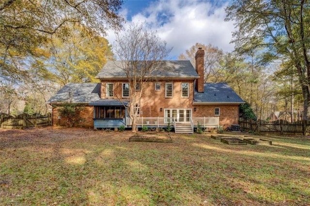 rear view of house with a yard and a deck