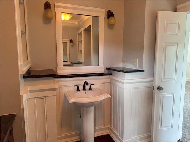 bathroom featuring a wainscoted wall and a sink