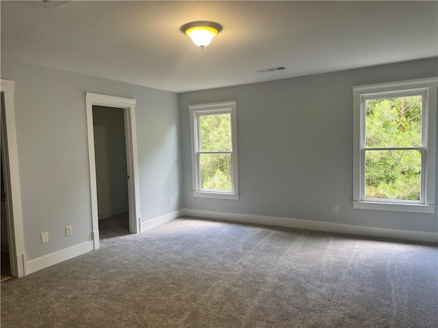 spare room featuring carpet flooring and baseboards