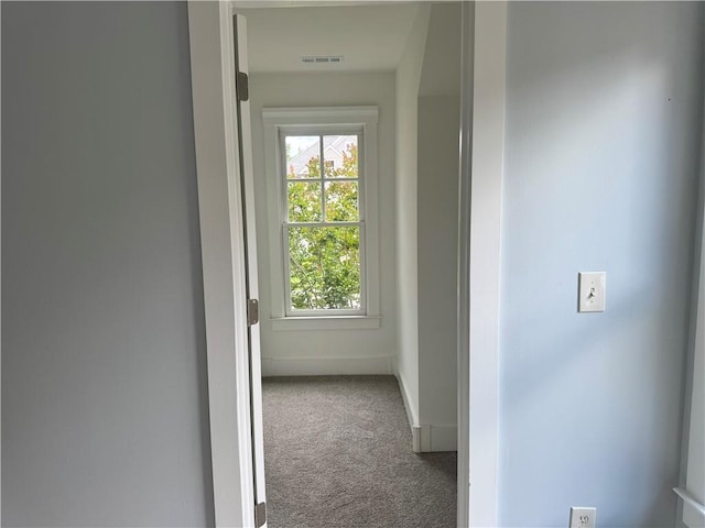 hallway with carpet flooring and baseboards